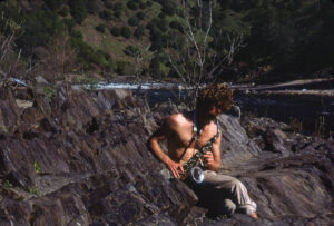 Scott Imsland playing his saxaphone by the river